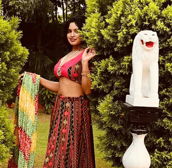 Neha Gupta web series shoot in a traditional embroidered outfit posing outdoors near a lion statue
